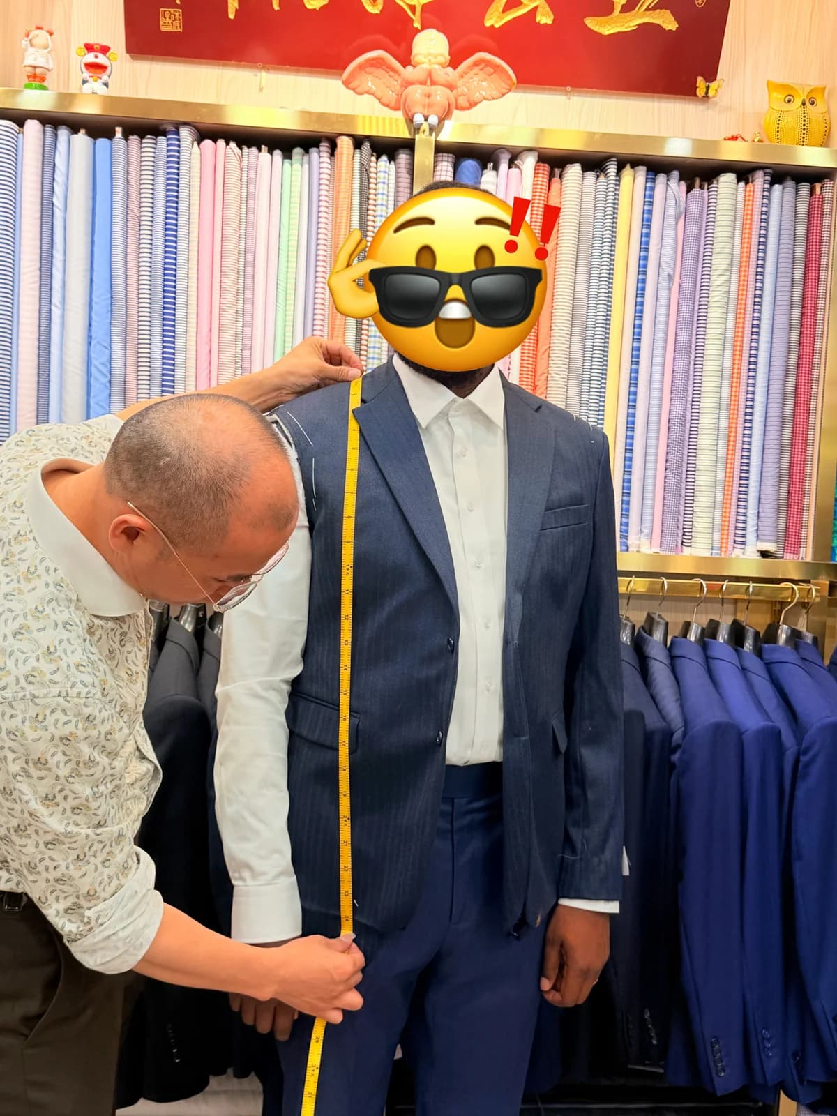 Wuyue tailor measuring a male client for a multi-suit business order at Shop 256 in Shanghai