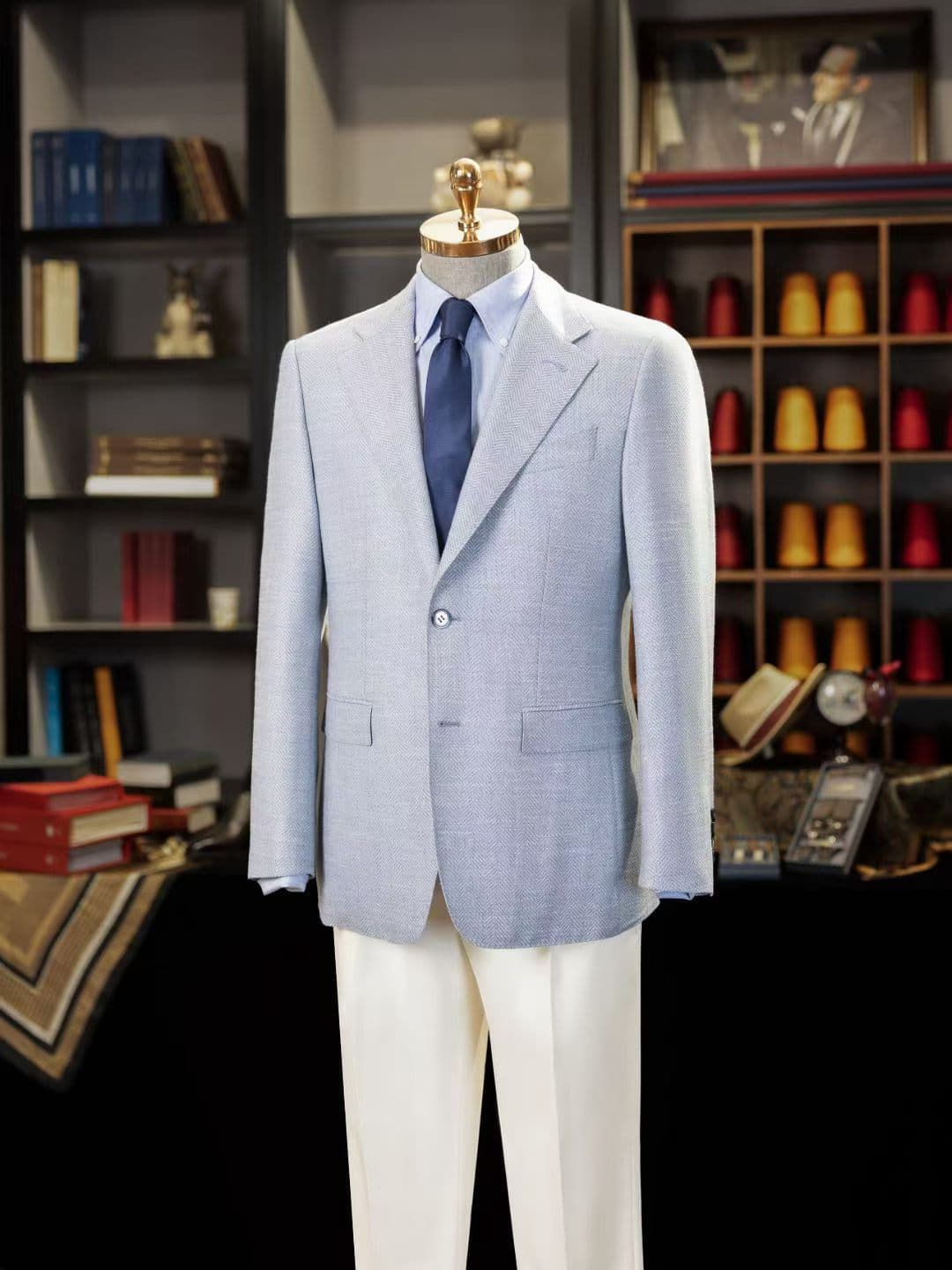 Finished light-blue herringbone custom jacket displayed with a blue tie at Wuyue Bespoke Tailoring