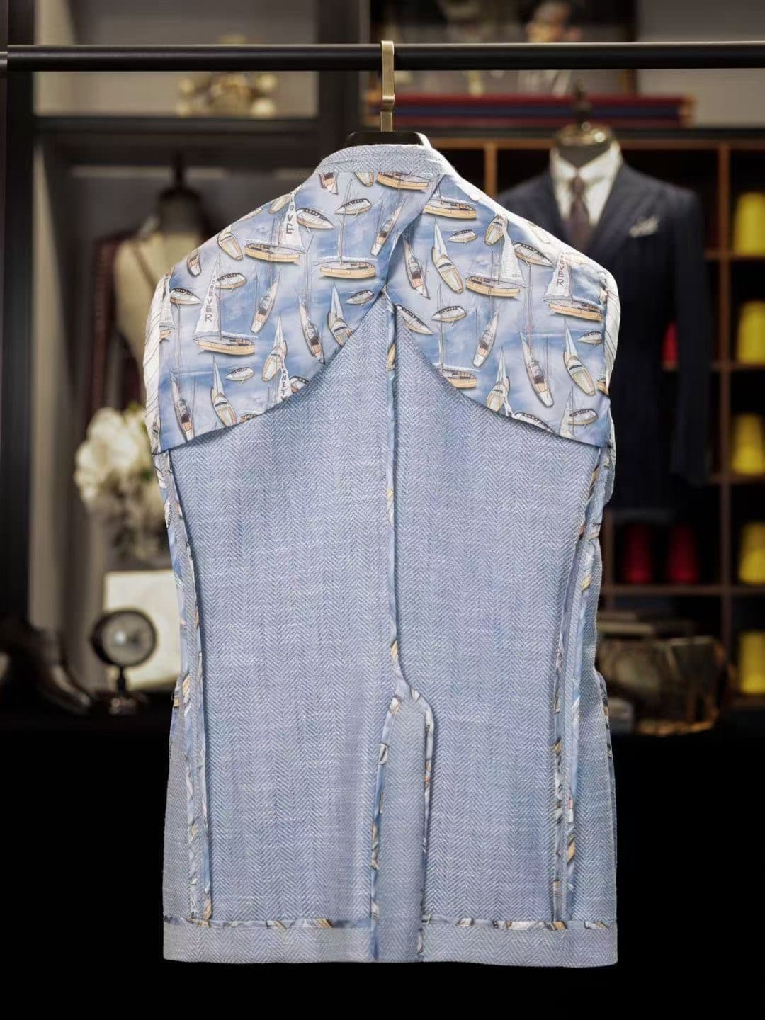 Inside back of a light-blue herringbone custom jacket with patterned lining and visible internal construction