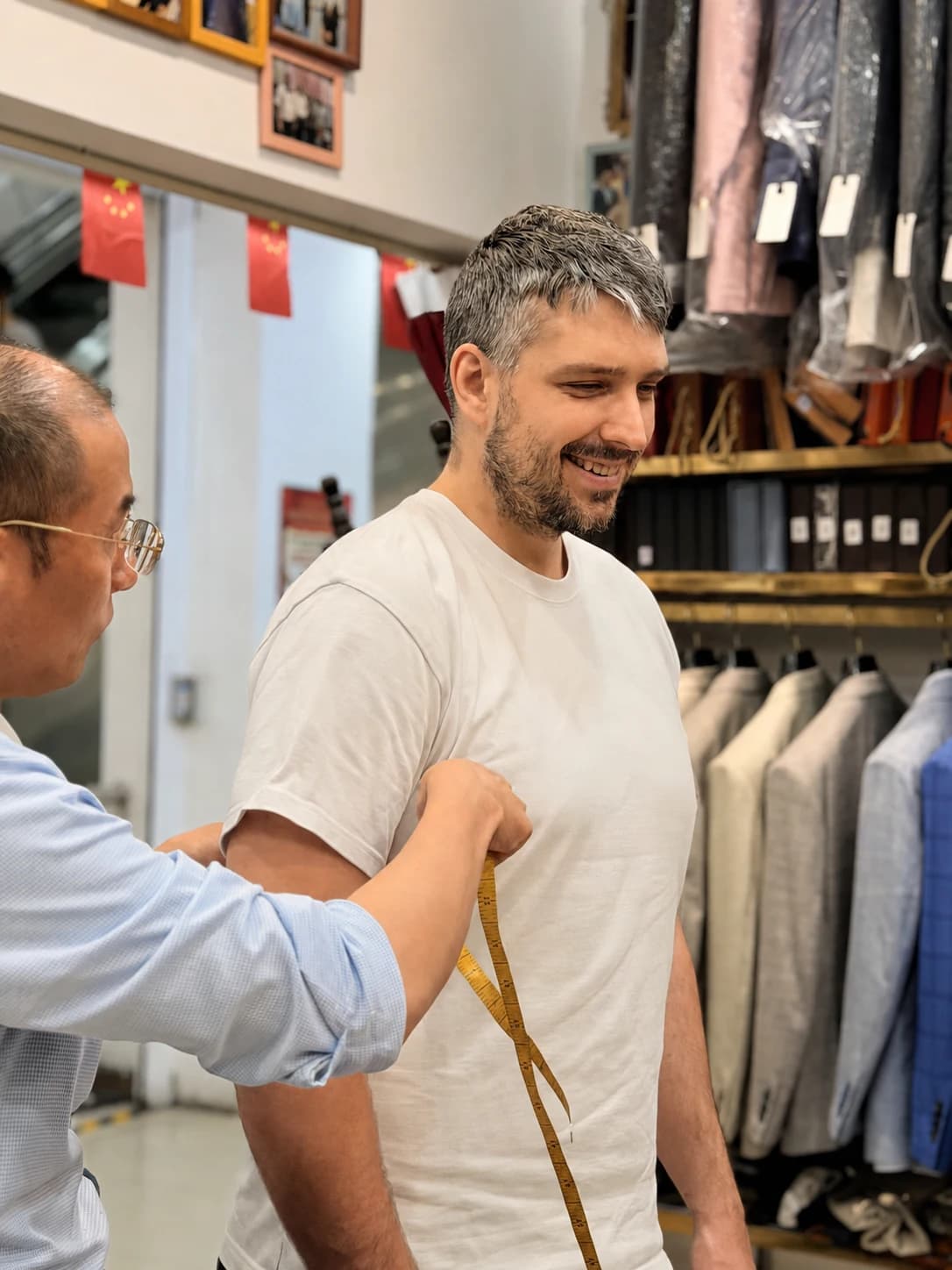 Wuyue tailor measuring a client's upper body