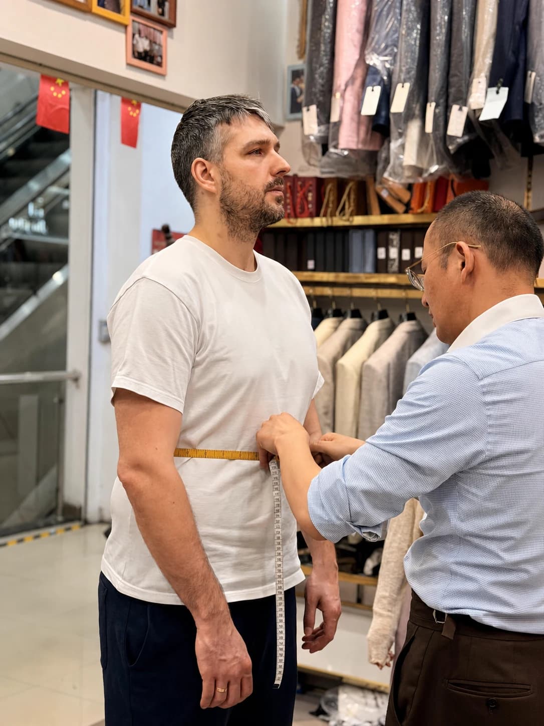 Wuyue tailor taking a client's waist measurement