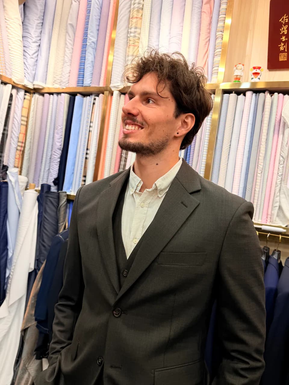 Wuyue client checking the fit of a finished three-piece suit in the Shanghai shop