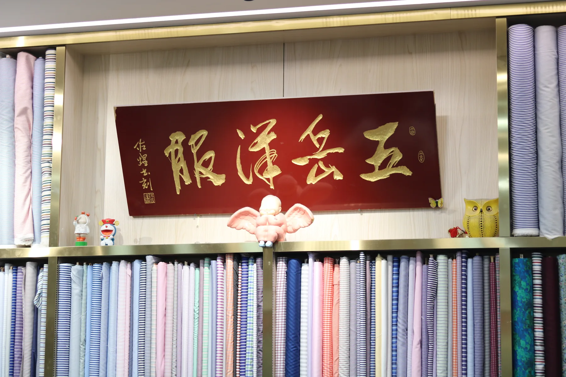 The Wuyue Chinese house sign surrounded by shelves of shirt fabrics