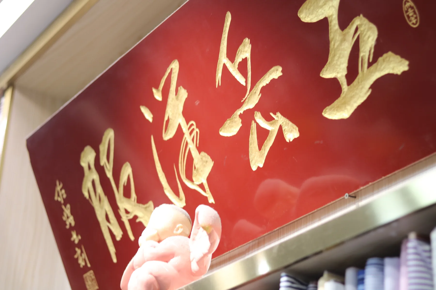 An angled close view of the red and gold Wuyue house sign