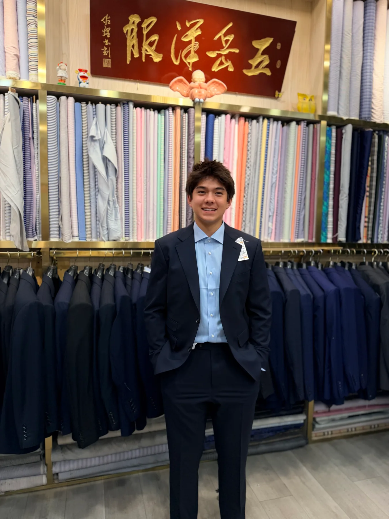 American client wearing a navy two-piece suit with an open-collar pale-blue shirt at Wuyue Shanghai
