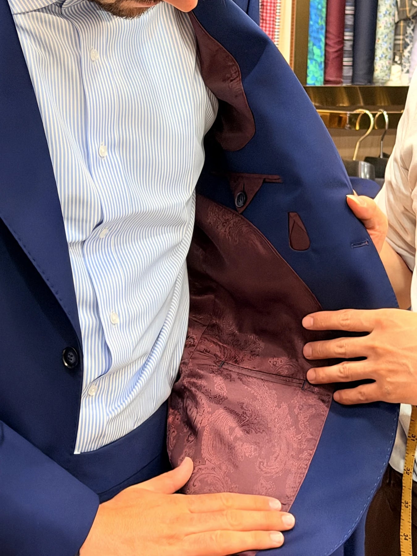 French blue suit jacket opened to show burgundy patterned lining and interior pockets
