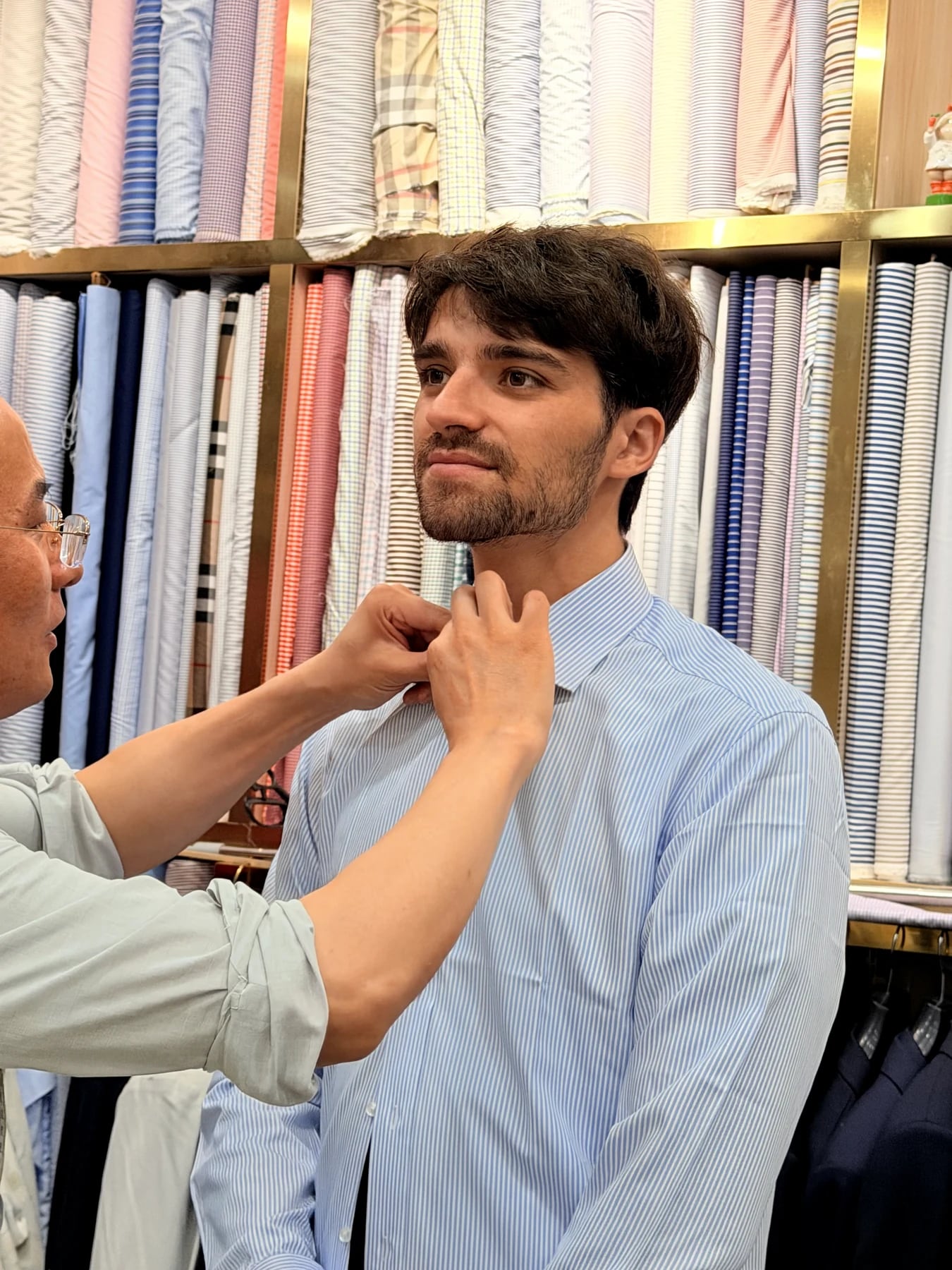 Wuyue tailor checking the shirt collar position during a French blue suit appointment