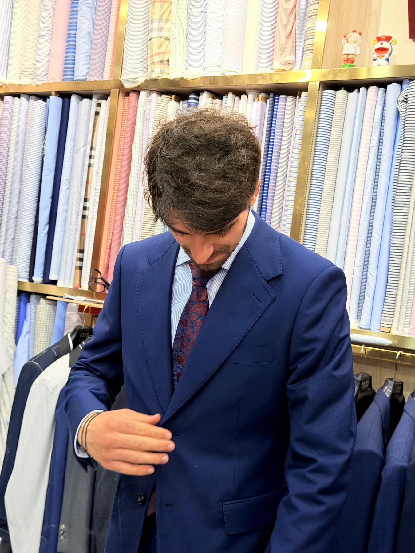 Client checking the front closure of a finished French blue business suit at Wuyue