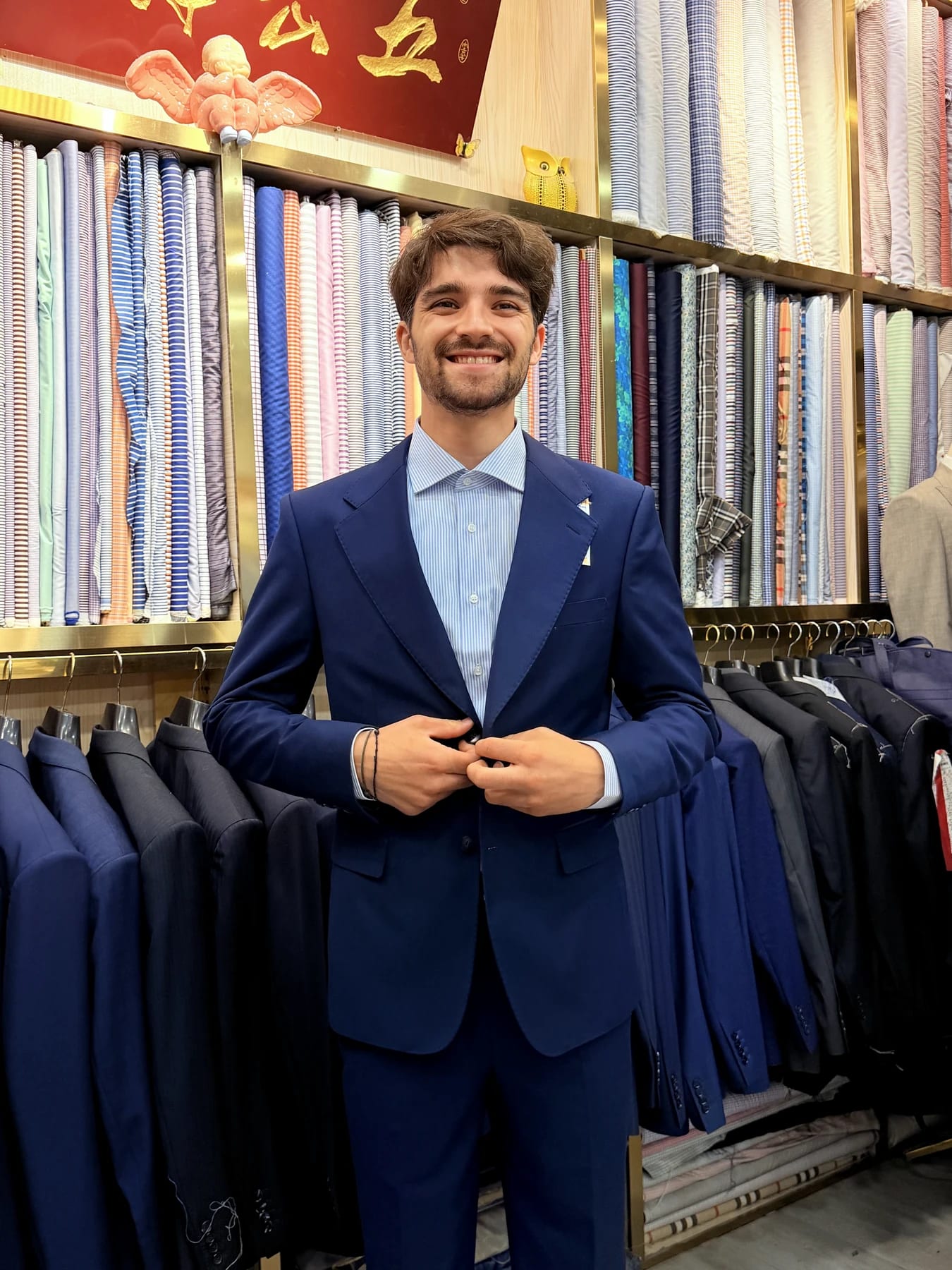 Client wearing a finished French blue two-piece suit with a striped shirt and burgundy tie at Wuyue Shanghai