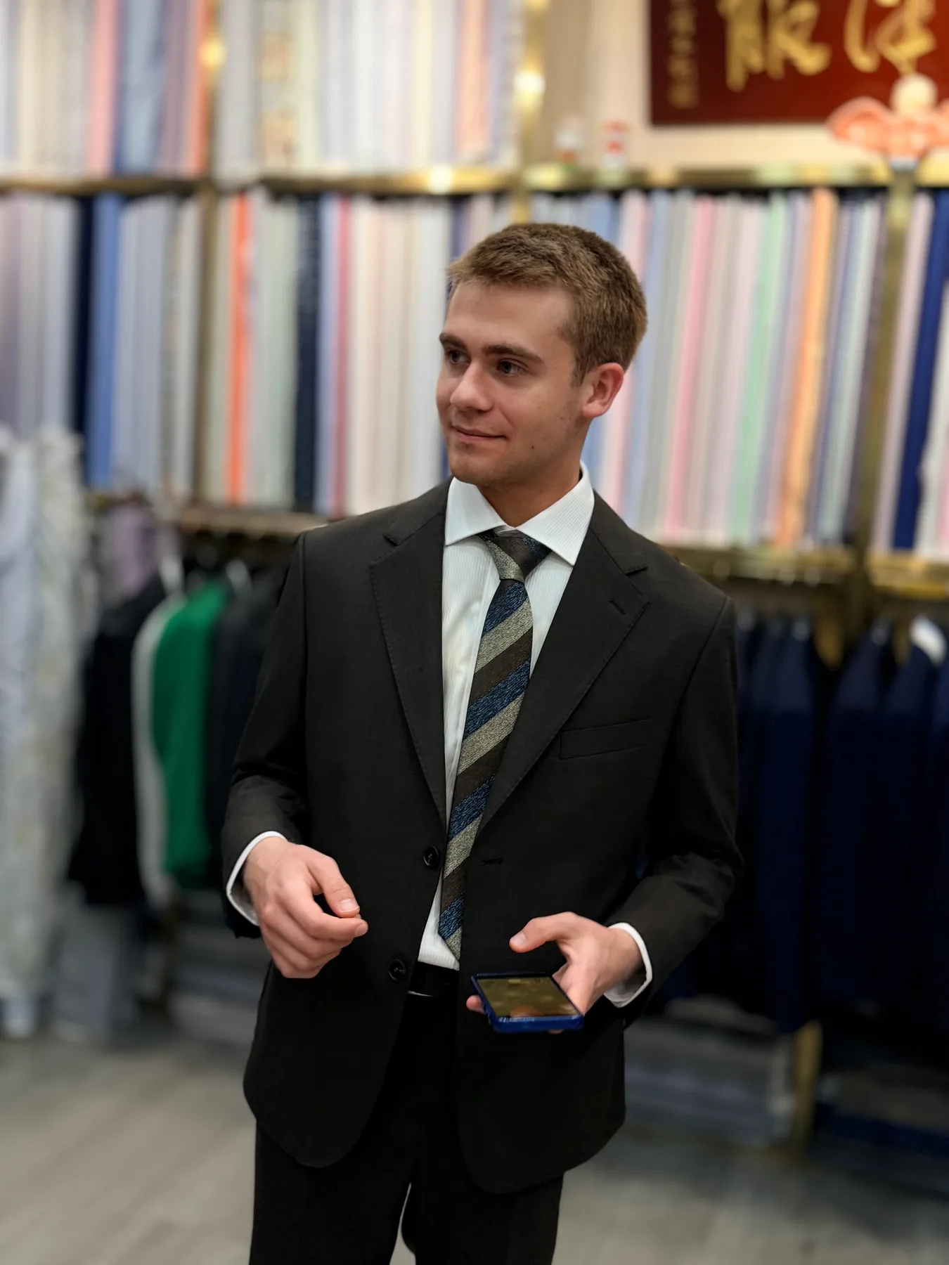 French student wearing a dark two-piece suit with a white shirt and striped tie at Wuyue Shanghai