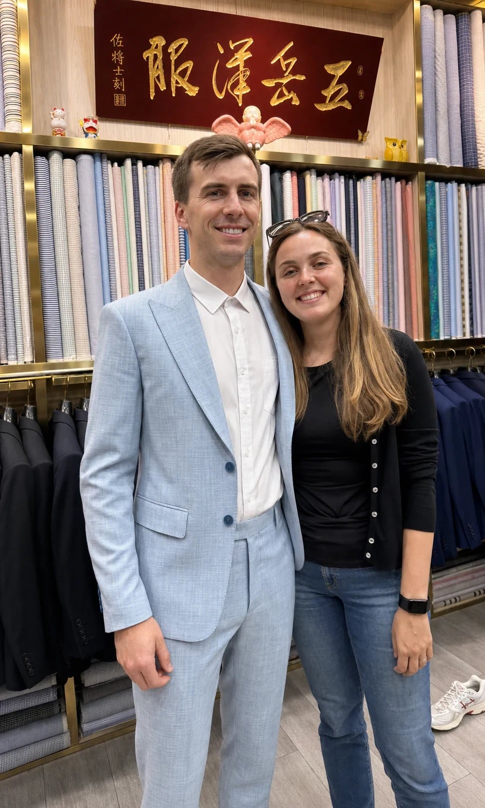 Client in a pale-blue suit standing with a companion inside the Wuyue shop