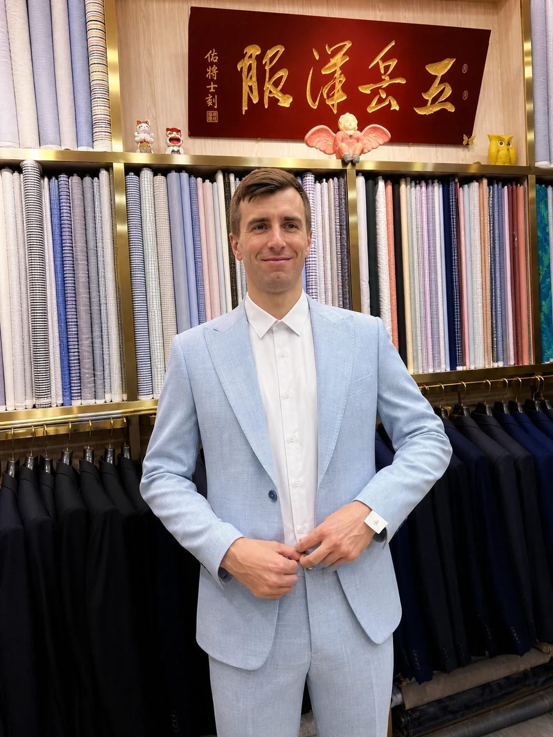 Client wearing a finished pale-blue two-piece suit with a white shirt at Wuyue Shanghai