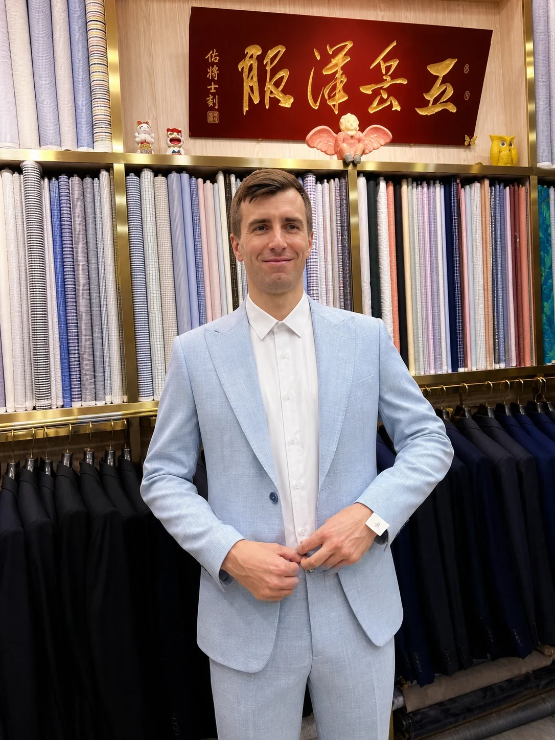 Client wearing a finished pale-blue two-piece suit with a white shirt at Wuyue Shanghai