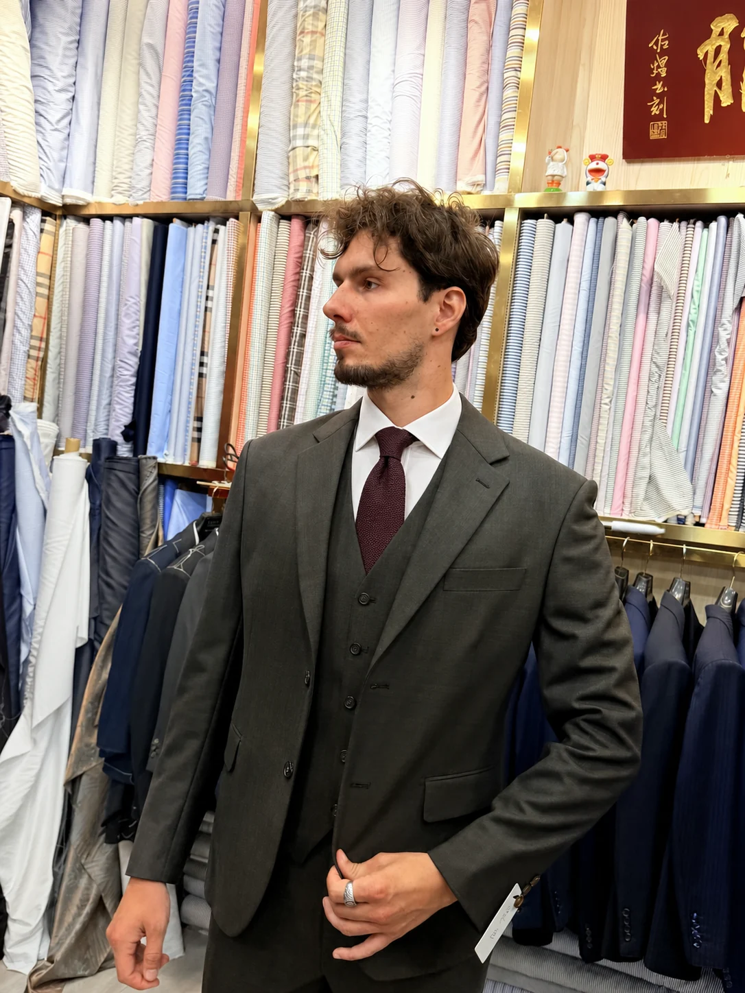 Client wearing a grey three-piece custom suit at Wuyue Bespoke Tailoring in Shanghai