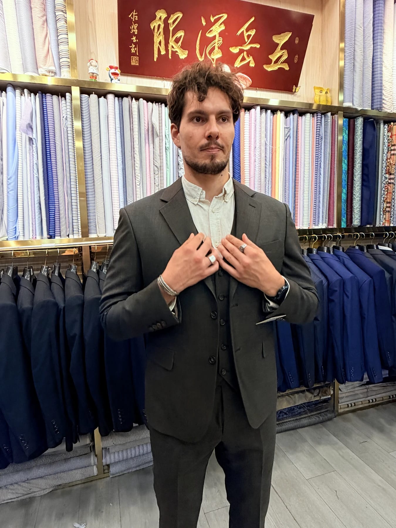 Client wearing a finished medium-grey three-piece suit with notch lapels at Wuyue Shanghai