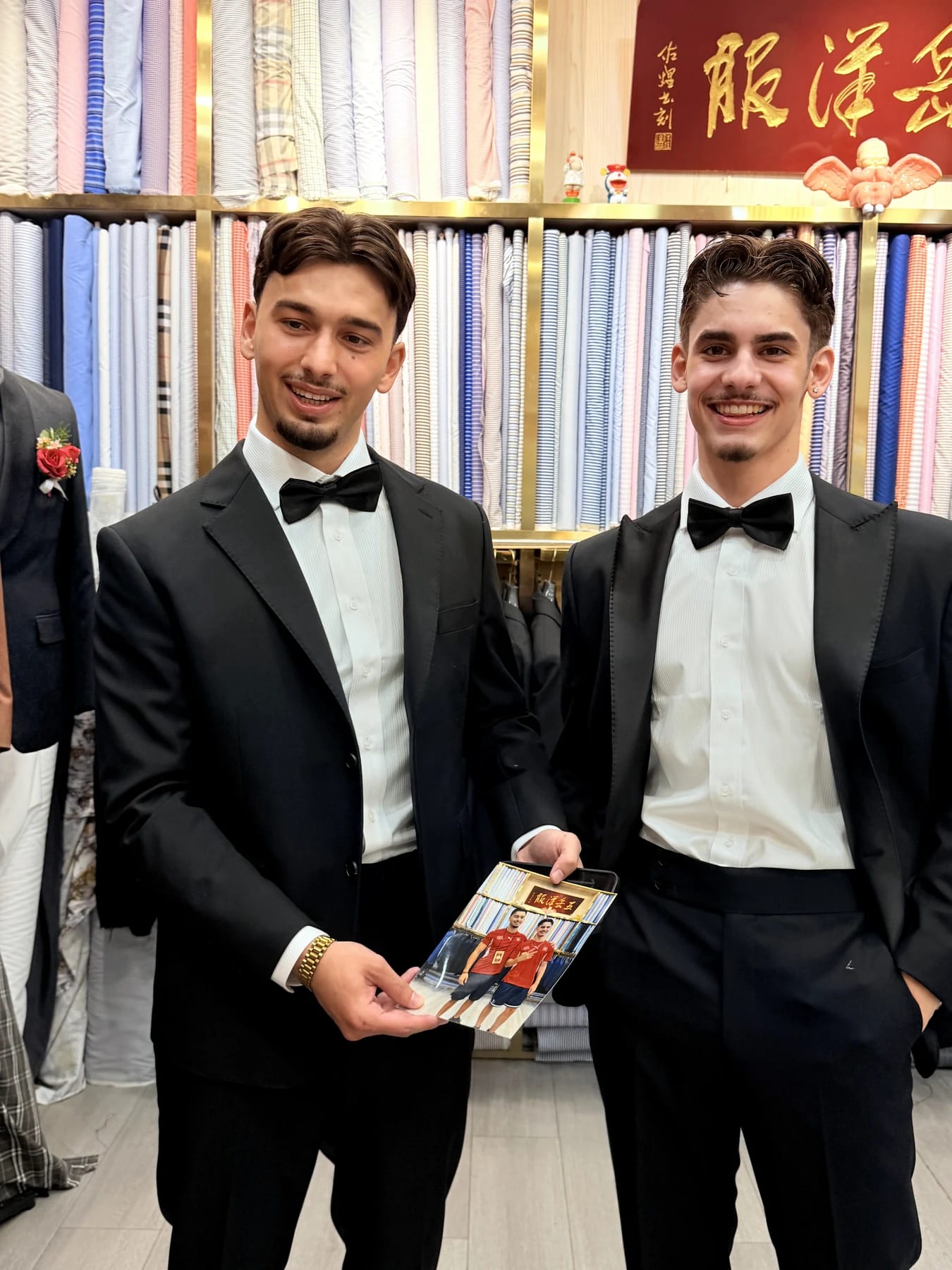 Two clients in black tuxedos at Wuyue with one holding a printed reference card