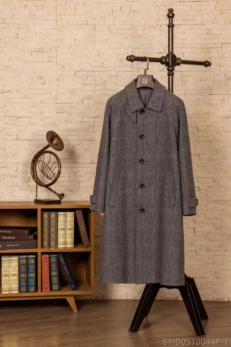 Grey herringbone single-breasted overcoat on a wooden hanger