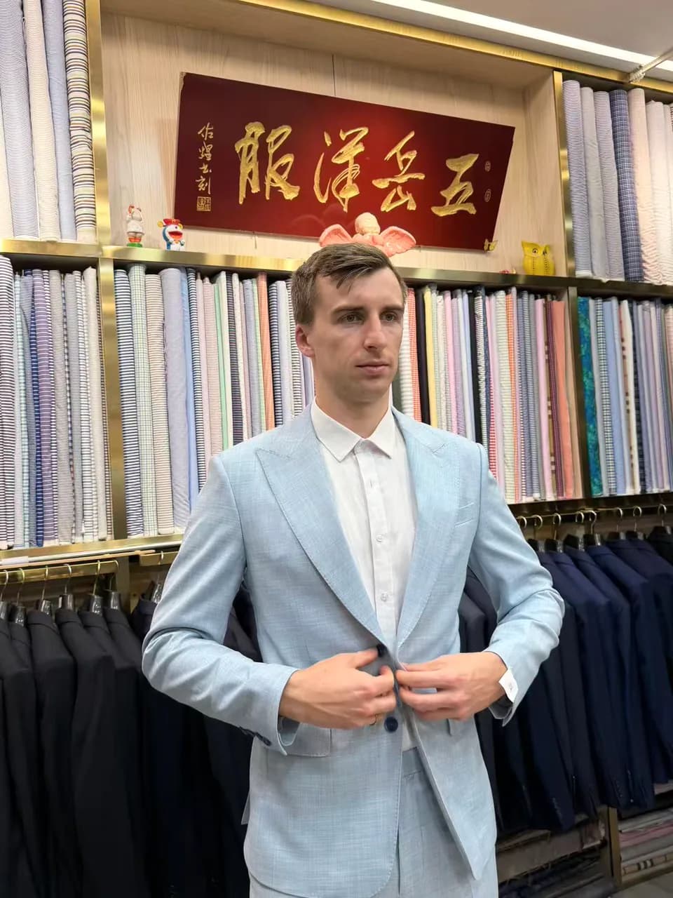 International visitor checking the fit of a finished custom suit at Wuyue in Shanghai