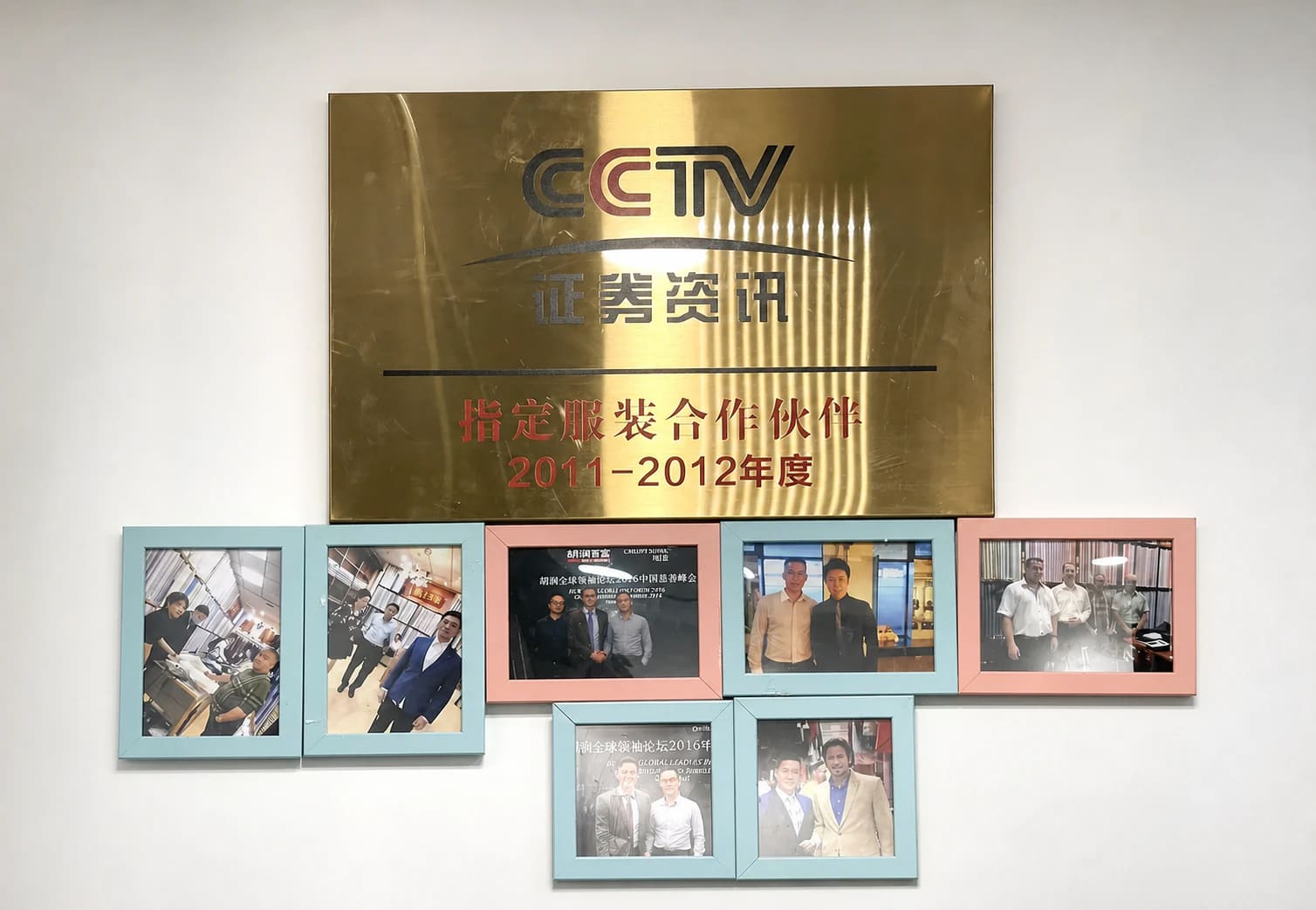 CCTV recognition plaque, framed client photos, and formalwear mannequins inside Wuyue Bespoke Tailoring