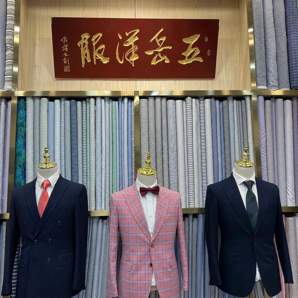 Wuyue Chinese shop sign above shirt fabric rolls and tailored jackets